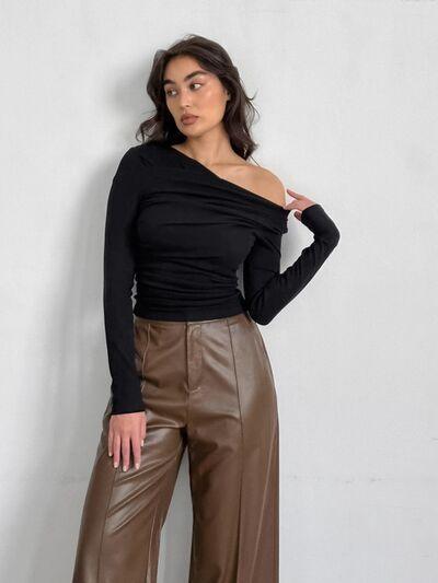 a woman wearing a black top and brown pants