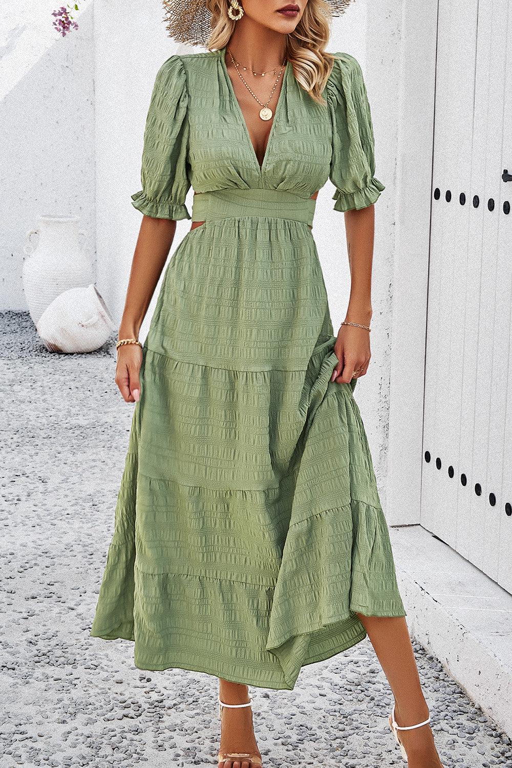 a woman wearing a green dress and straw hat