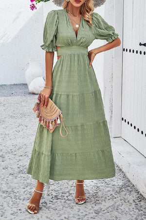a woman wearing a green dress and hat
