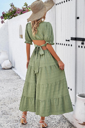 a woman wearing a green dress and a straw hat