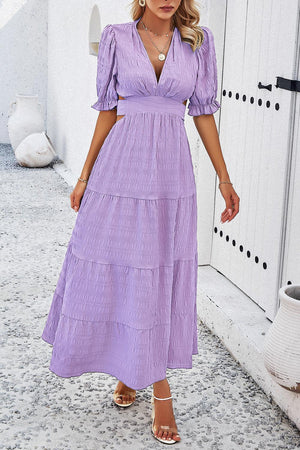 a woman in a purple dress standing in front of a door