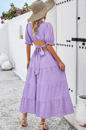 a woman wearing a purple dress and a straw hat