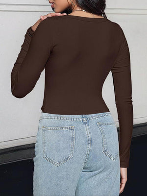 a woman wearing a brown top and jeans