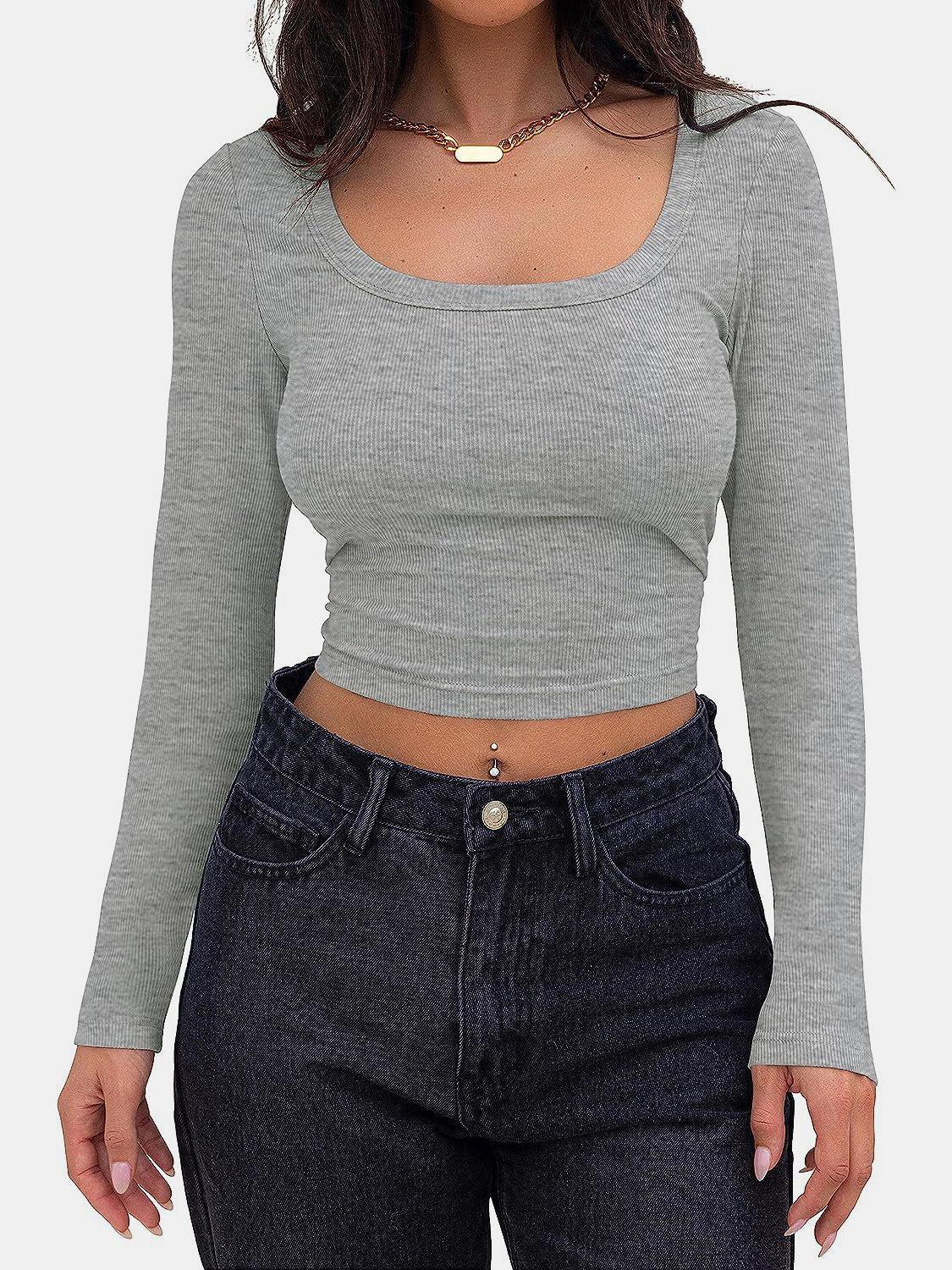 a woman wearing a grey crop top and jeans