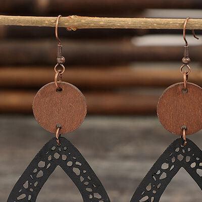 a pair of wooden earrings hanging from a wooden stick
