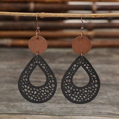 a pair of earrings hanging from a wooden stick