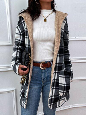 a woman wearing a plaid coat and jeans