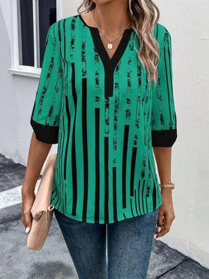 a woman wearing a green and black striped top