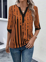 a woman wearing an orange and black striped top