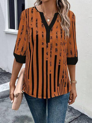 a woman wearing an orange and black striped top