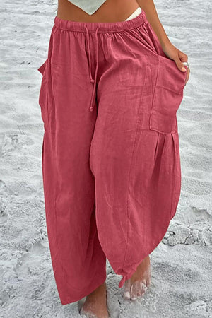 a woman standing in the sand with her hands on her hips