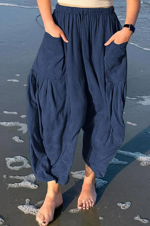 a woman standing on a beach with her feet in the sand