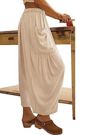 a woman in a white dress leaning on a table