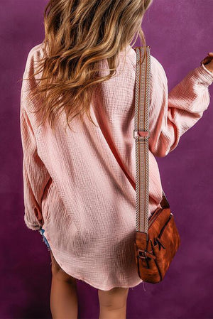 a woman in a pink shirt holding a brown purse