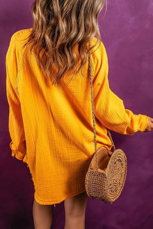 a woman in a yellow dress holding a straw bag