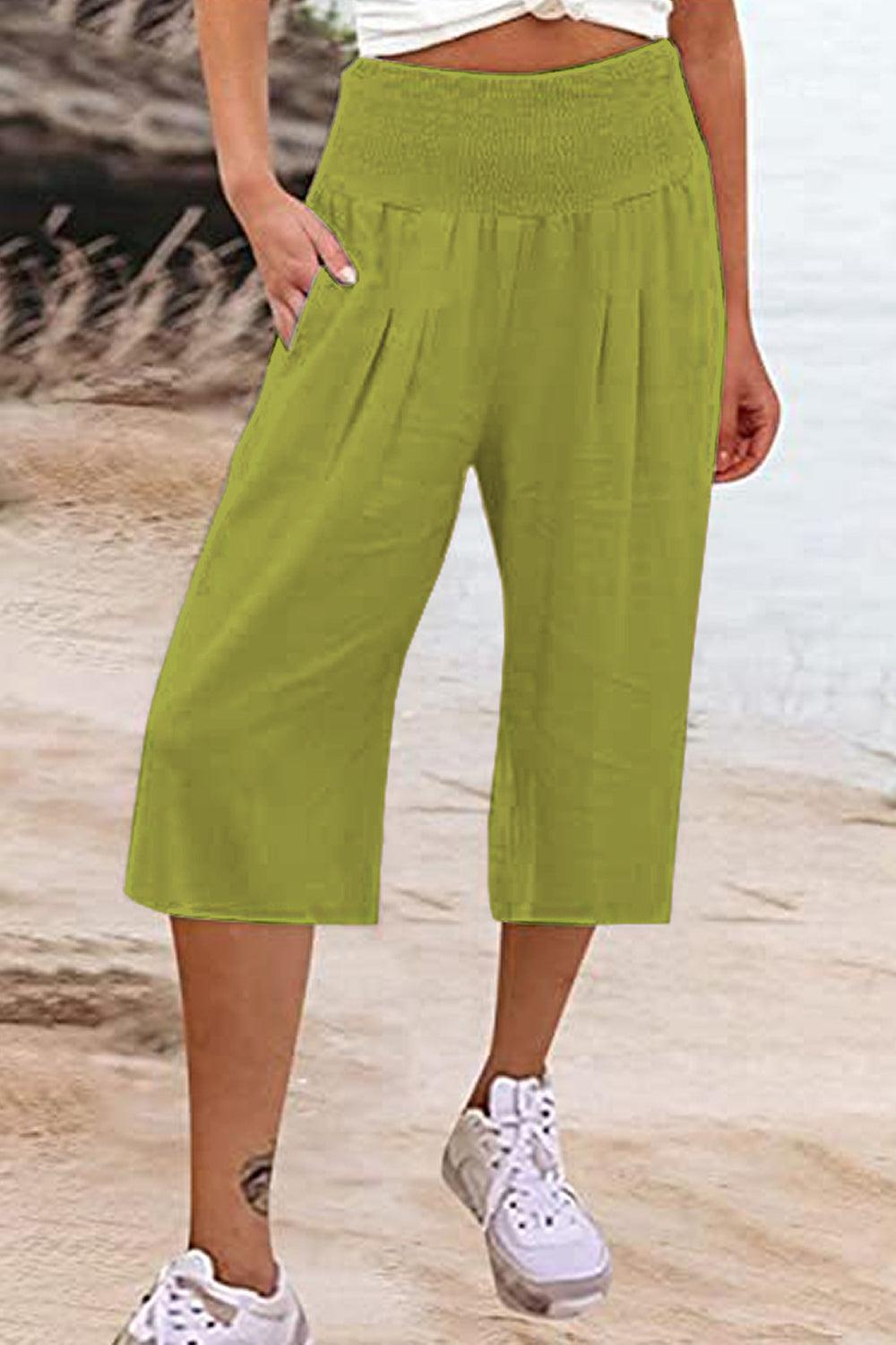 a woman standing on a beach next to a body of water