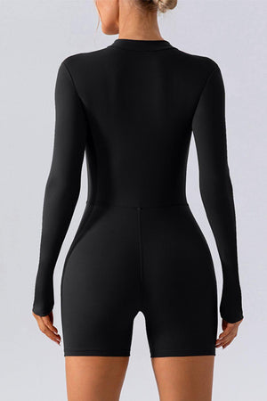 a woman wearing a black bodysuit with long sleeves