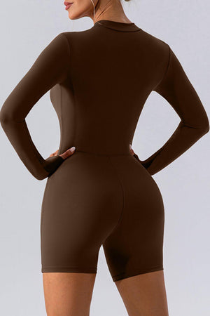 a woman in a brown bodysuit with her hands on her hips