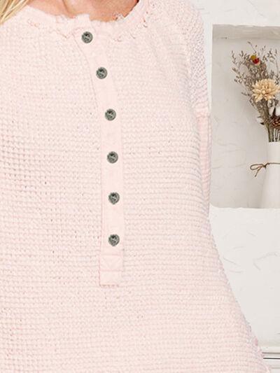 a woman wearing a pink sweater with buttons