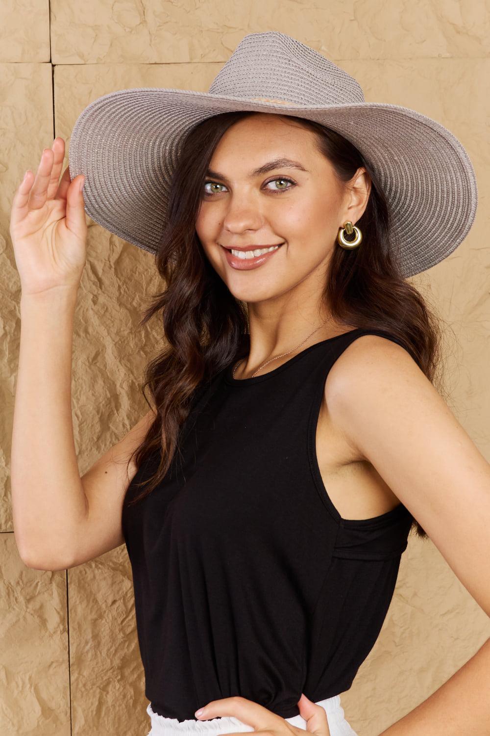 a woman in a hat poses for a picture