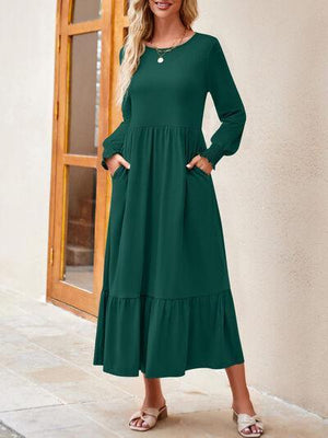 a woman standing in front of a door wearing a green dress