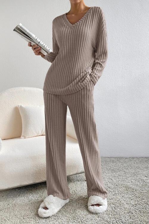a woman in a sweater and pants holding a hair dryer
