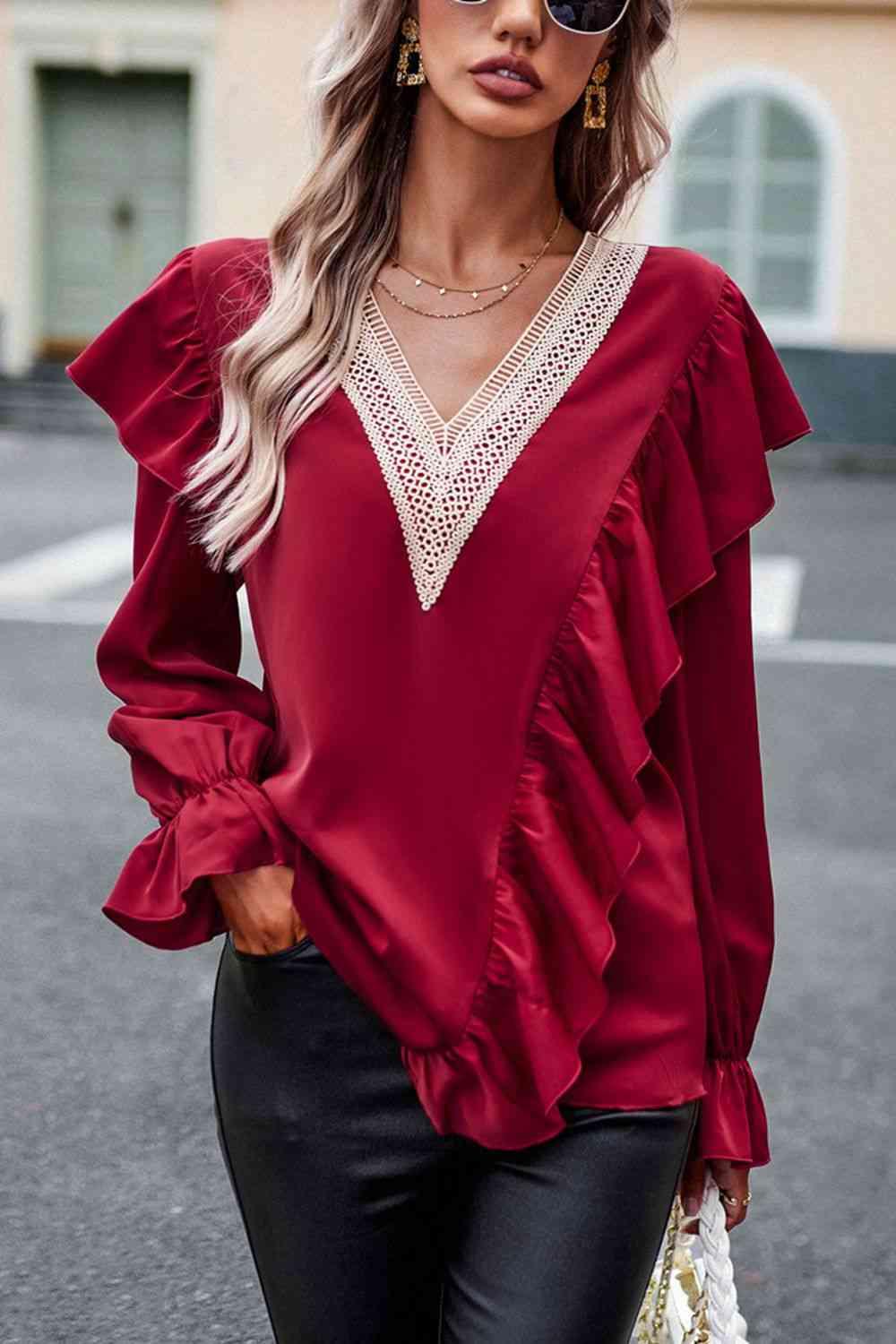 a woman wearing a red blouse and black pants