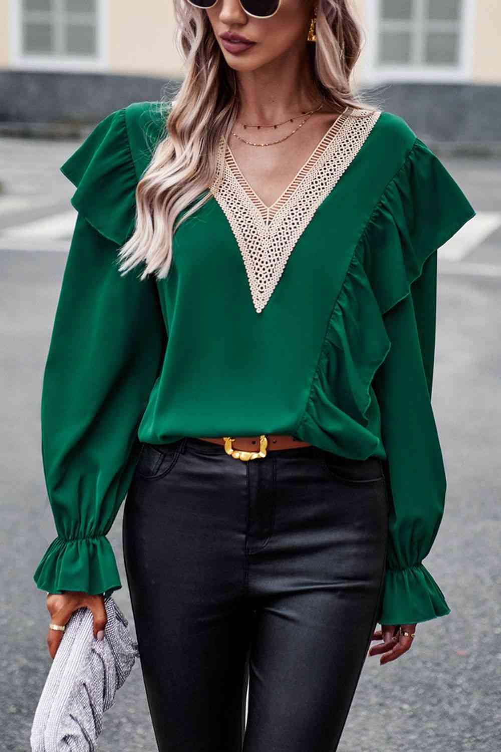 a woman wearing a green top and black pants