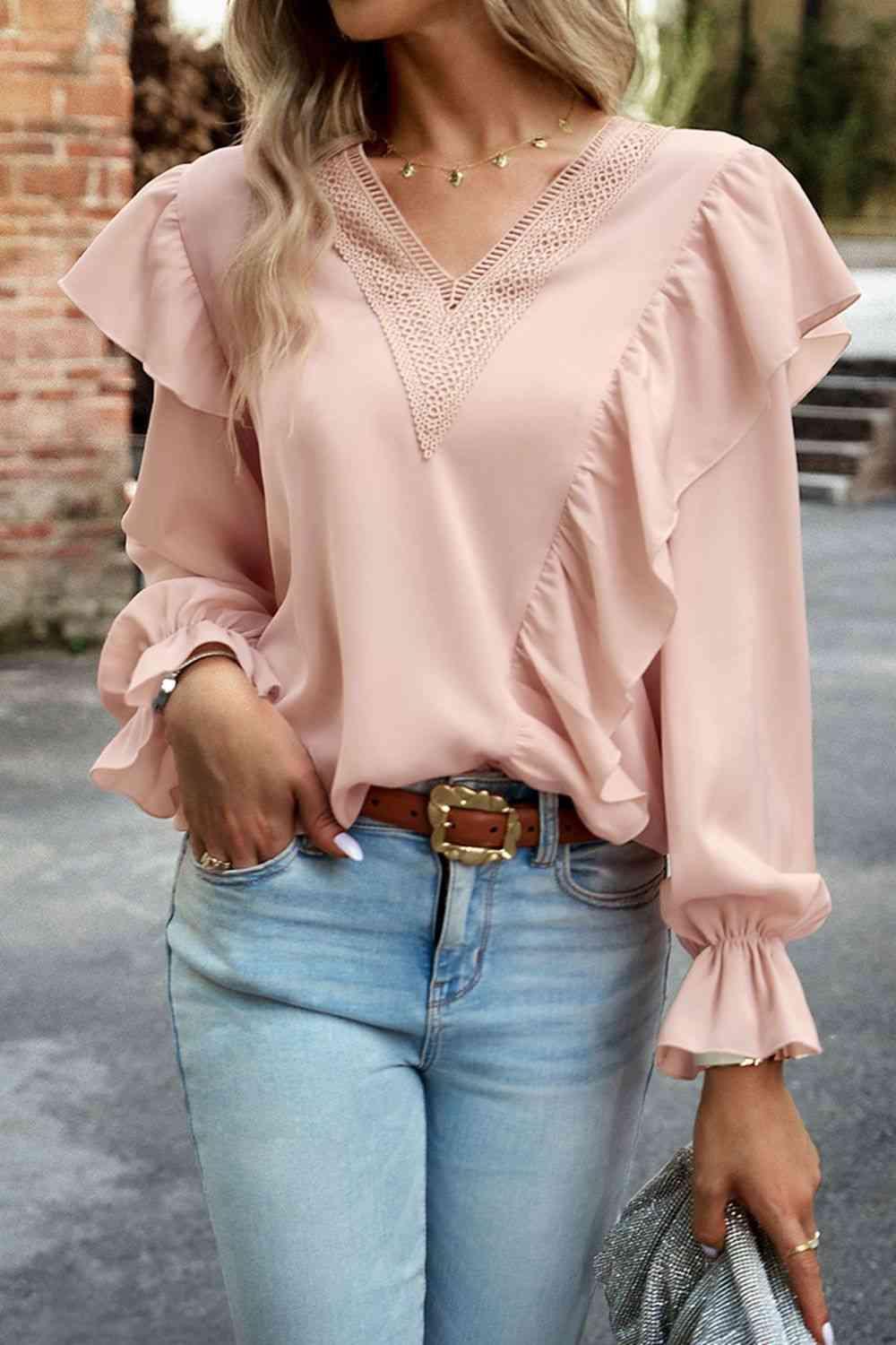 a woman wearing a pink blouse and jeans