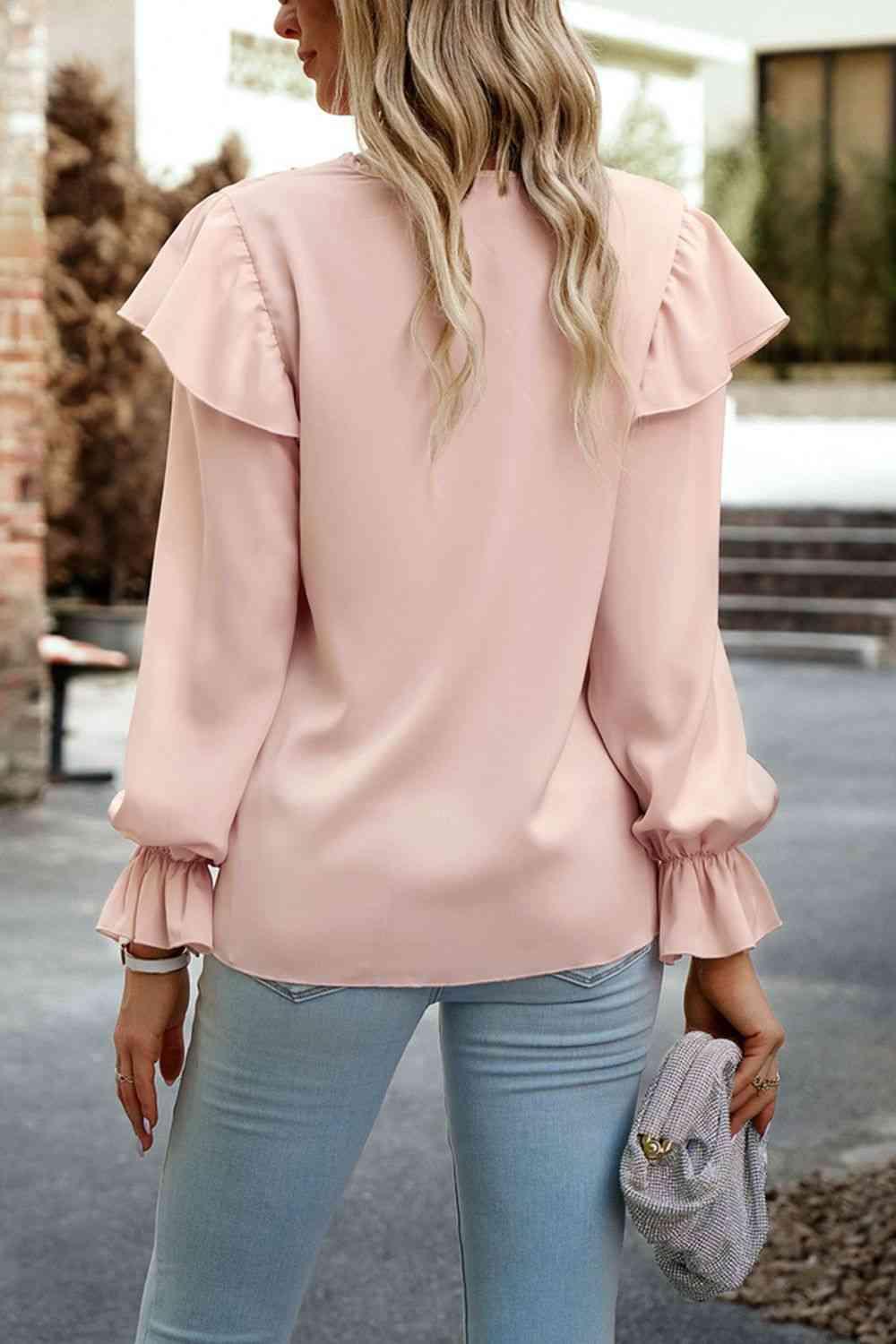 a woman wearing a pink blouse and jeans