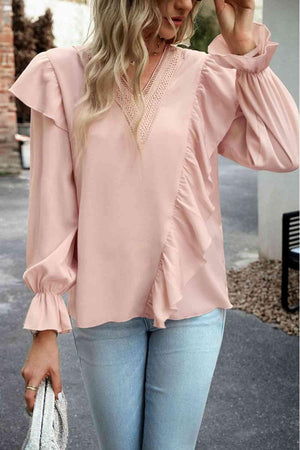 a woman wearing a pink blouse and jeans