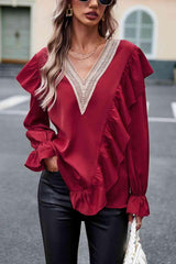 a woman wearing a red blouse and black pants