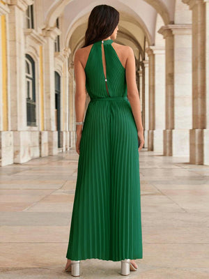 a woman in a green dress standing in a hallway