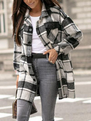 a woman is walking down the street wearing a plaid coat