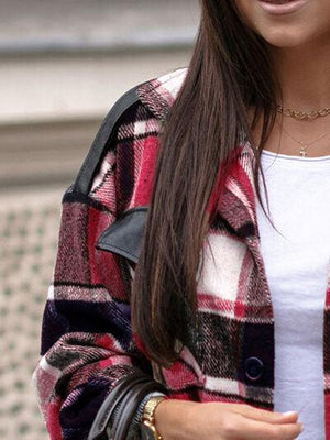 a woman in a plaid jacket is holding a cell phone