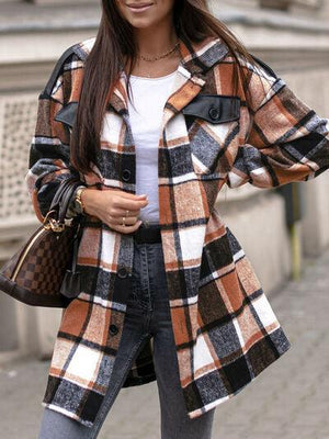 a woman wearing a plaid coat and hat