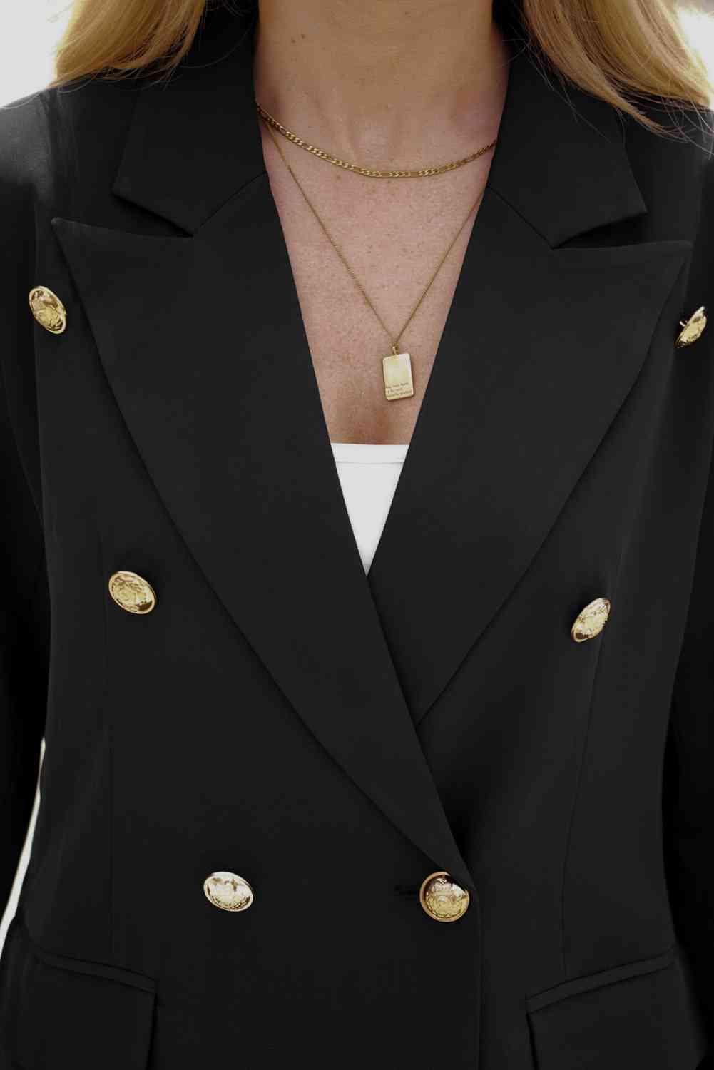 a woman wearing a black jacket with gold buttons