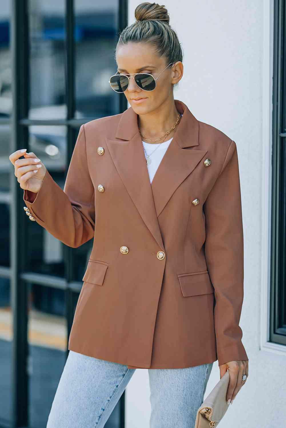 a woman wearing a brown blazer and jeans