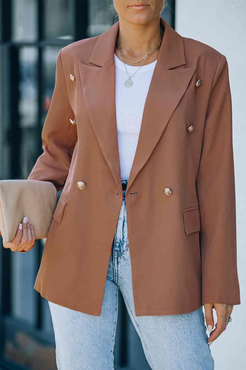 a woman wearing a brown blazer and jeans