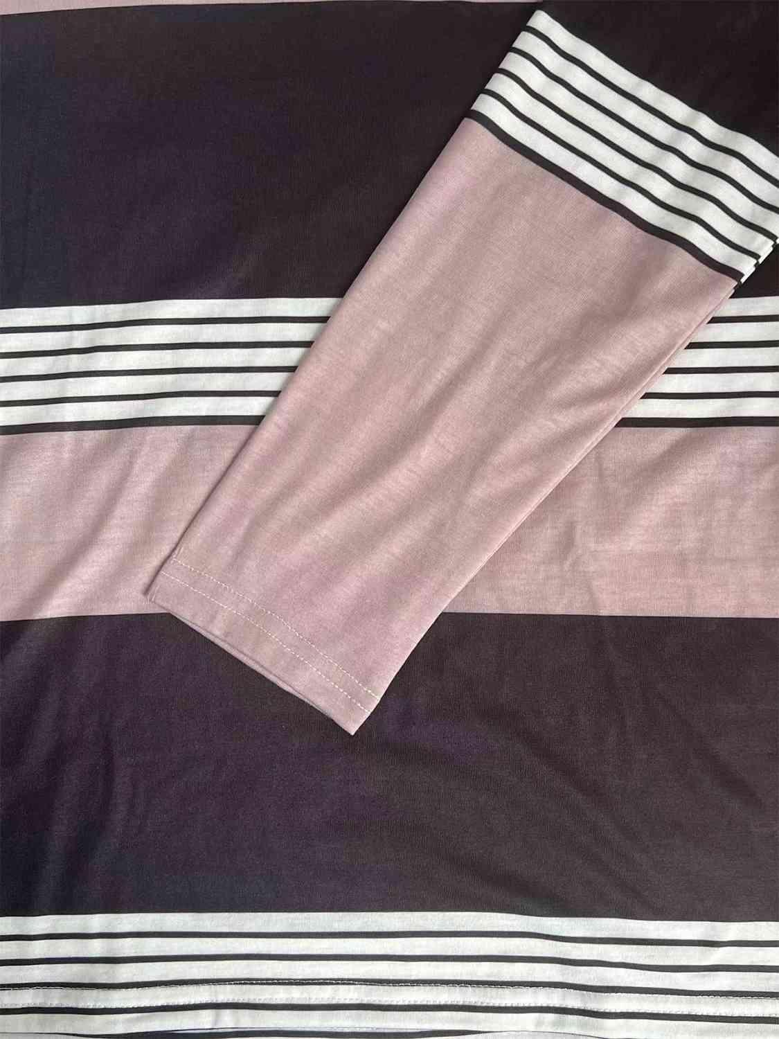 a black and white striped blanket laying on top of a bed