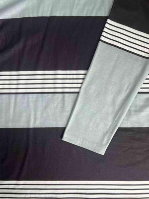 a black and white striped blanket laying on top of a bed