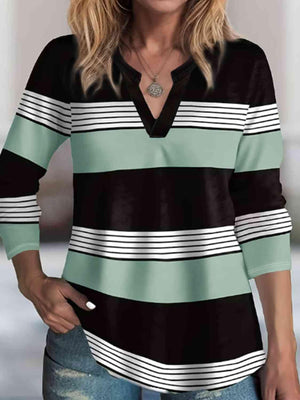 a woman wearing a black and green striped shirt