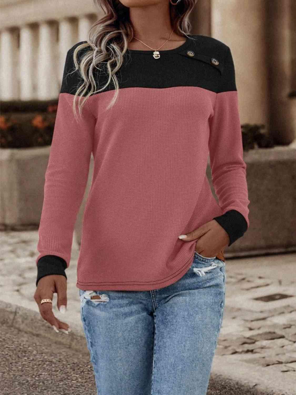 a woman wearing a pink and black sweater