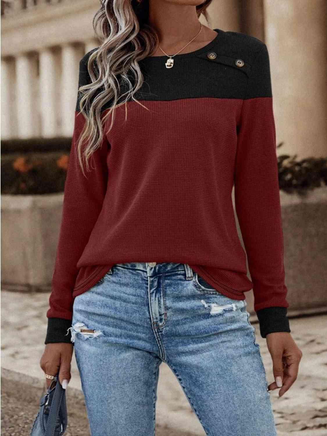 a woman wearing a red and black sweater