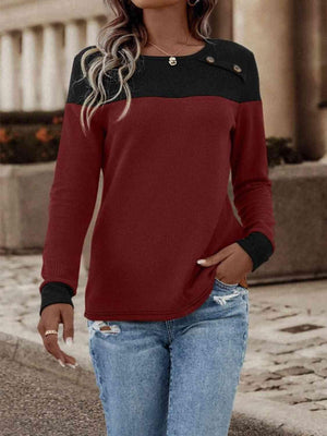 a woman wearing a red and black sweater