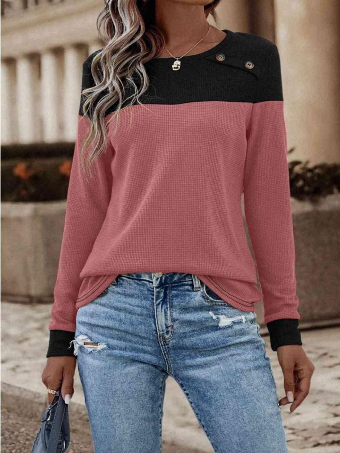 a woman wearing a pink and black sweater