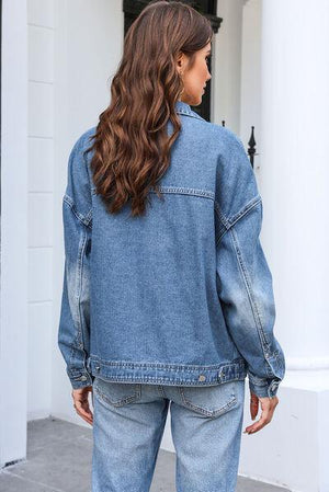 a woman standing outside of a house wearing a jean jacket