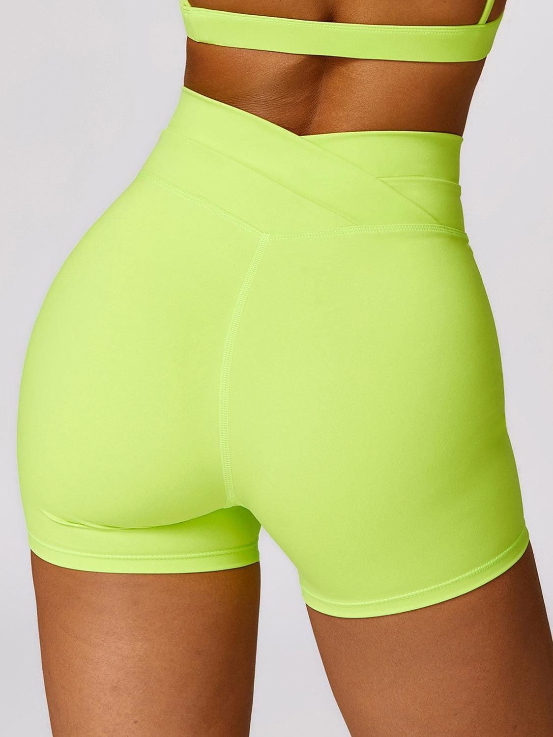 a woman in neon green shorts and a bra