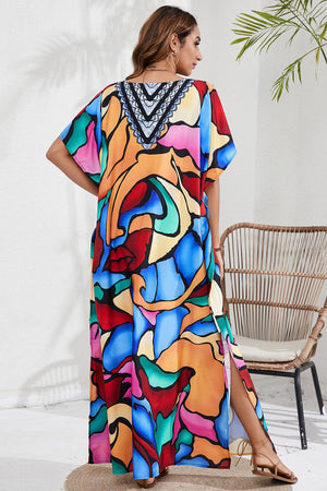 a woman in a colorful dress standing next to a chair