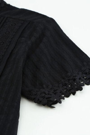 a close up of a black dress on a white surface